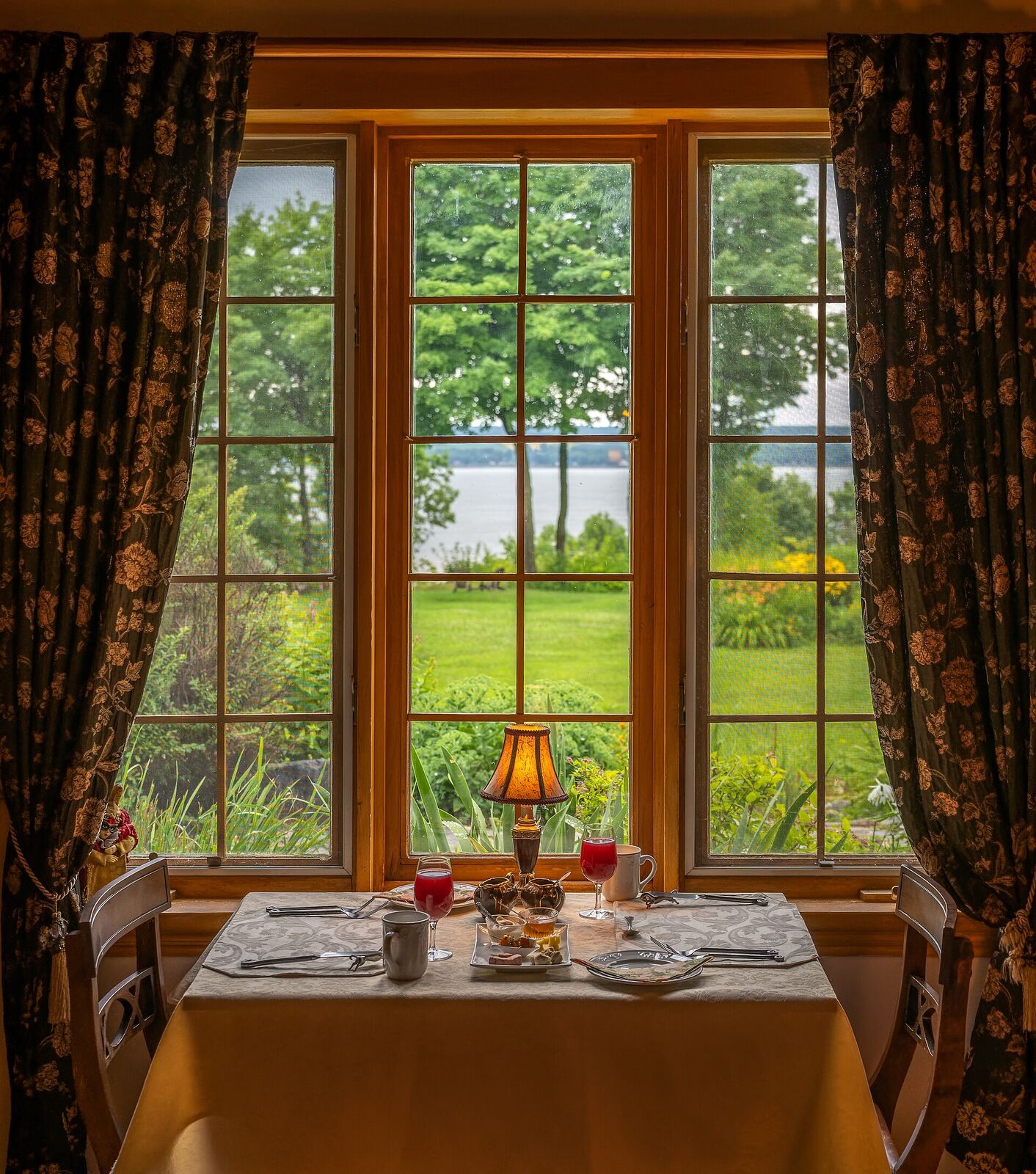 Gedeckter Frühstückstisch vor einem Fenster mit Blick in den Garten
