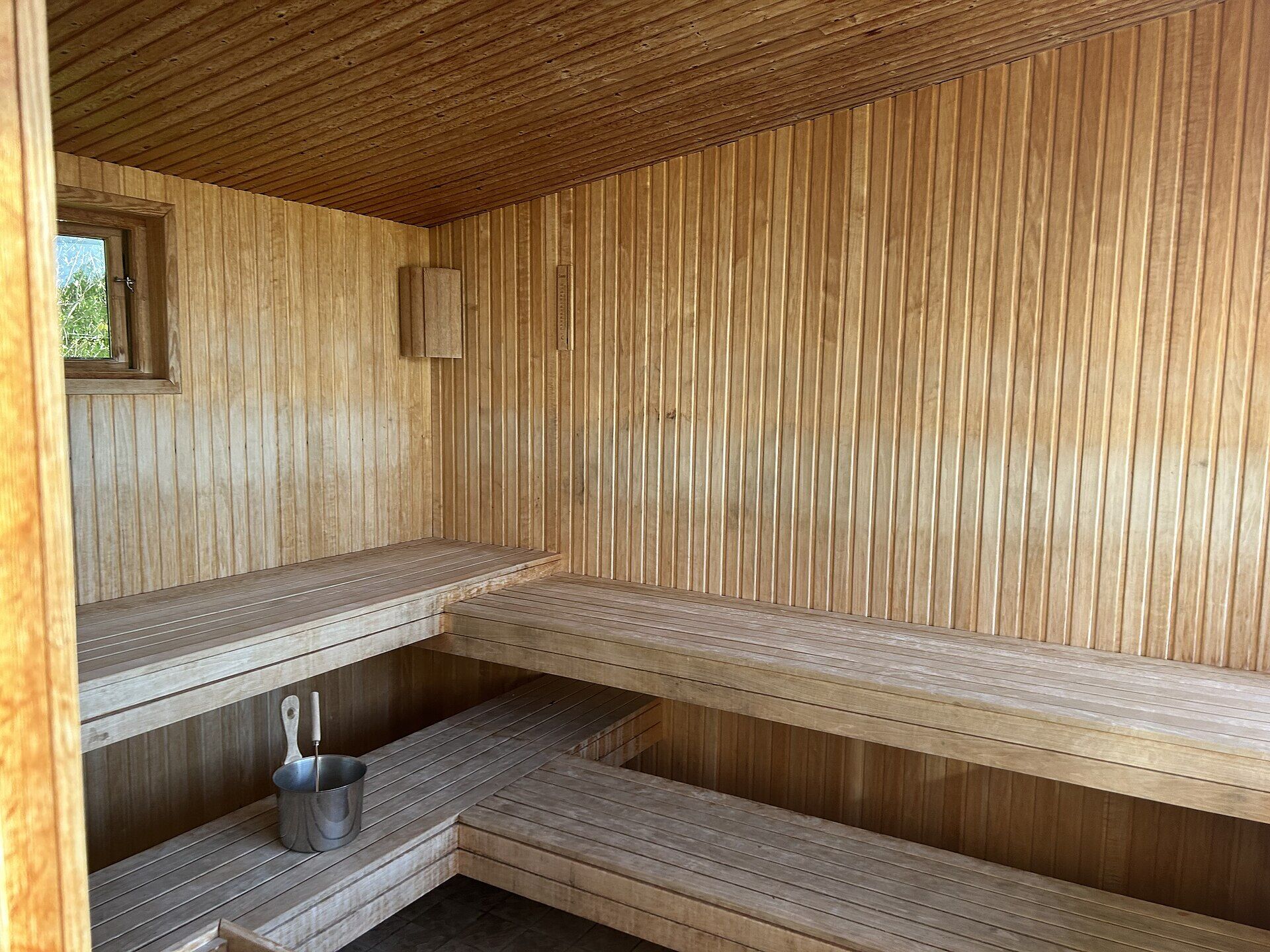 Holzsauna mit Bänken aus hellem Holz